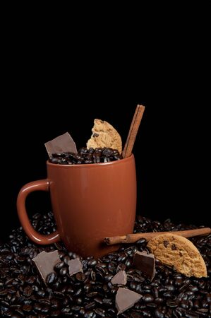 Coffee mug with coffee beans, cinnamon sticks and chocolateの写真素材