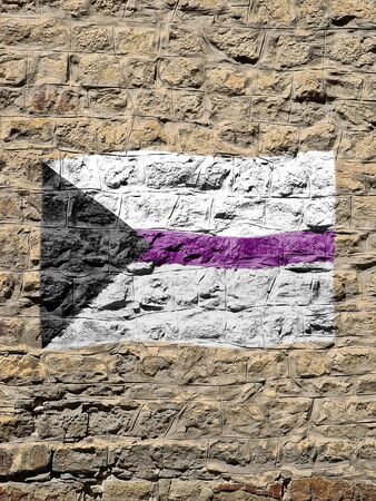 Rocky wall with a demisexual flag painted waving on it .の写真素材