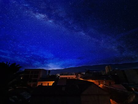A photo of a view of the sky from the old neighborhood in the City at night with a lot of starsの写真素材