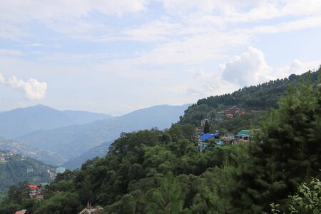 Landscape of mountains and small houses over it in Sikkim, Indiaの写真素材