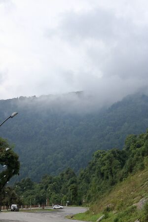 A road on the mountain with heavy cloudy sky over in Sikkim, Indiaの写真素材