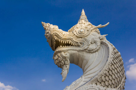 stone serpent king of Nagas near the river in blue skyの写真素材