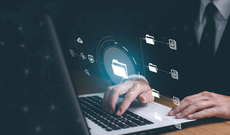 Online documentation database and document management system concept. Businessman working on laptop with virtual screen. Process automation to efficiently manage files.の写真素材