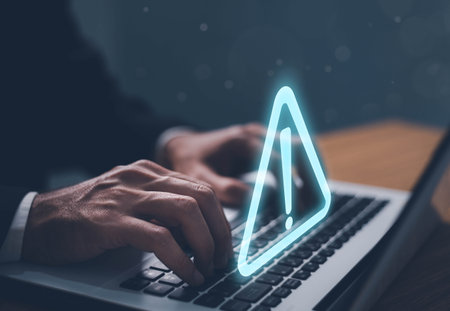 Error and maintenance alert. Businessman using computer laptop with triangle caution warning sing for notification error and maintenance concept.の写真素材