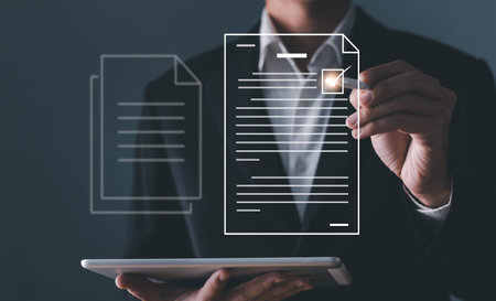 A businessman using a pen signing electronic documents on digital documents on a virtual screenの写真素材