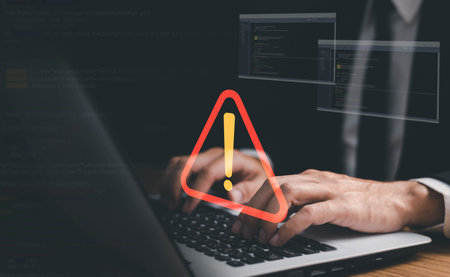 Businessman or it staff , programmer, developer using computer laptop with triangle caution warning...
