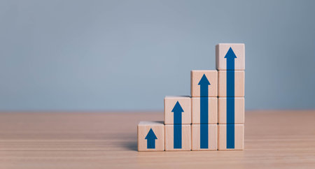 business growth success process concept. wood block stacking as step stair with arrow up. plan growth and increase of positive indicators in his business.の写真素材