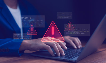 Cybersecurity warning concept. Warning icon and programming code. Data breach, system error, hacking attempt, software development issues and bug fixing process. Cyber security and IT support.の写真素材