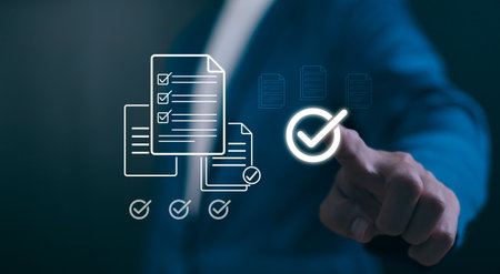 Digital Quality Assurance concept. Hand verifying a checklist icon, symbolizing business compliance, standards management, and successful audit completion.の写真素材