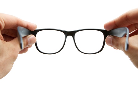 Human hands holding retro style eyeglasses