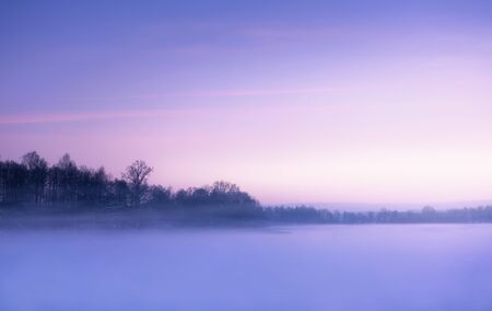 Winter landscape, foggy morning over frozen lake with copy spaceの写真素材