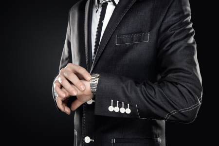 Close up of elegant man checking the time isolated on gray background with copy spaceの写真素材