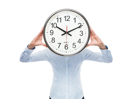 Deadline concept, close up of young businesswoman covering her face with analog clock isolated on white backgroundの写真素材