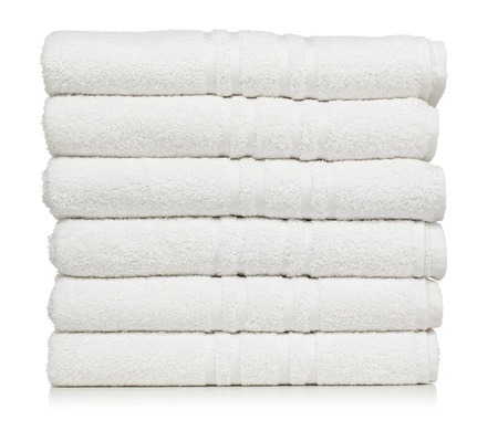 Stack of white plush hotel towels isolated on white backgroundの写真素材