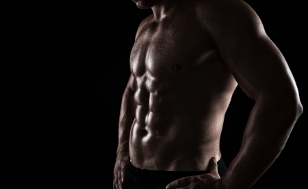 Close up of perfect male body isolated on black background with copy spaceの写真素材