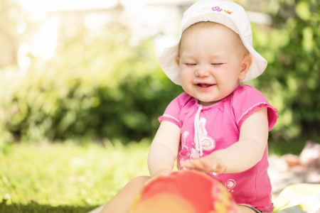 Portrait of cute little baby girl playing in the gardenの写真素材