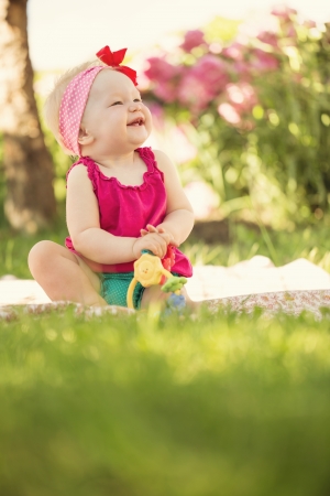 Portrait of cute little baby girl playing in the garden with copy spaceの写真素材