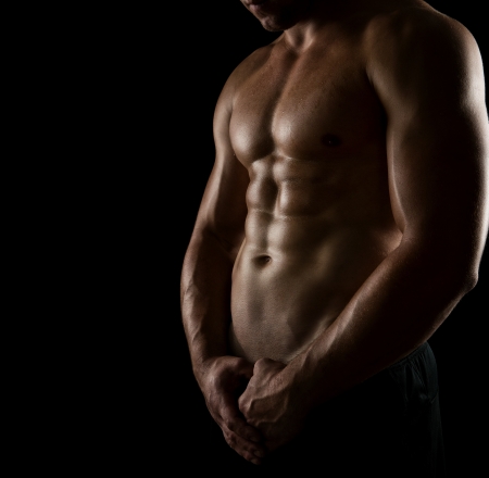 Close up of perfect male body isolated on black background with copy spaceの写真素材