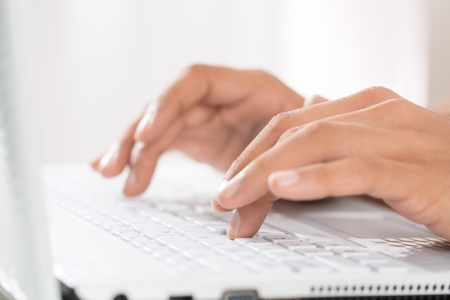 Close up of male hands typing on a laptopの写真素材