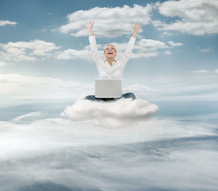 Reach the sky concept  Young succesful  businesswoman with laptop sitting on the cloudの写真素材