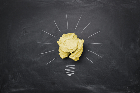 Great idea concept, crumpled paper on the chalkboard turned into a light bulbの写真素材