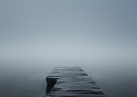 Close up of wooden jetty in the winter fog with copy spaceの写真素材