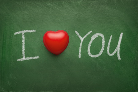 I love you text written on the chalkboard with red rubber heartの写真素材