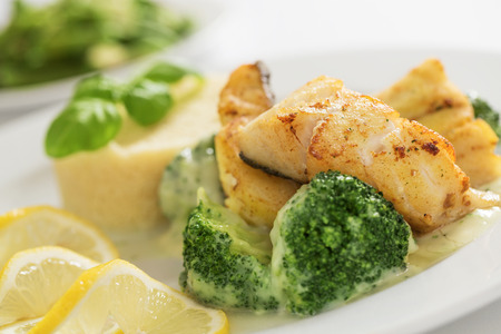 Close up of grilled cod fish fillet with couscous, broccoli and green beansの写真素材
