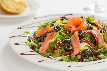 Close up of fresh salmon salad with dried tomatoes, olives and sesame seedの写真素材
