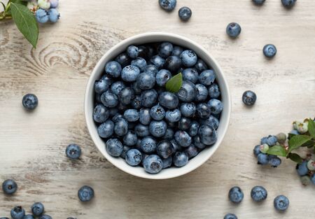 High angle view of a cup of blueberries on the old wooden deskの写真素材
