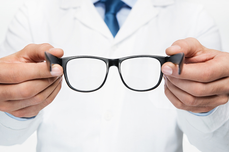 Close up of doctor oculist, optometrist holding new eyeglassesの写真素材