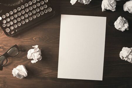Retro writer, journalist desk. High angle view of blank paper sheet on a wooden desk with copy spaceの写真素材