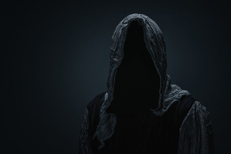 Silhouette of a Grim Reaper over dark gray background with copy spaceの写真素材