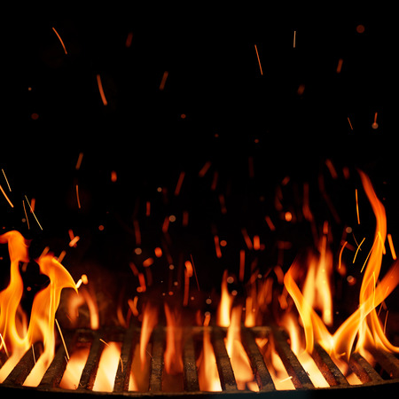 Empty grill, barbeque grid with fire isolated on black background with copy spaceの写真素材