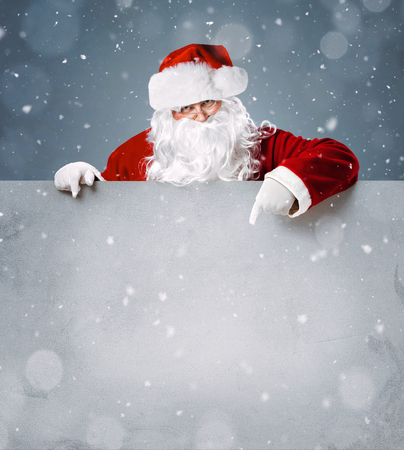 Santa Claus pointing on blank advertisement banner with copy spaceの写真素材