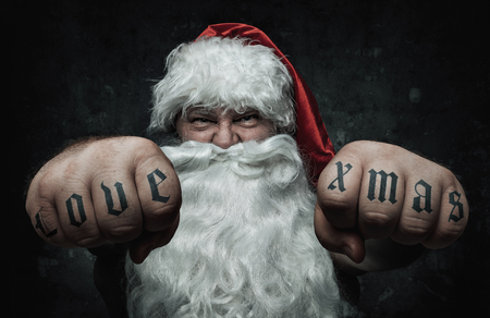 Funny, mad Santa Claus showing fists with tattooの写真素材