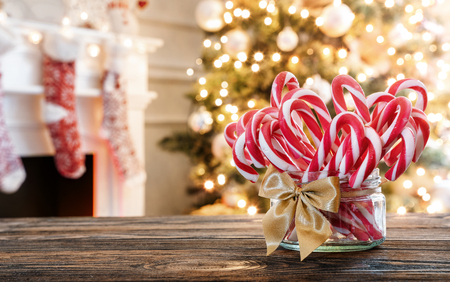 Candy canes in the glass jar on the christmas table with copy spaceの写真素材
