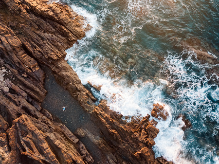 High angle view of a man relaxing in the natural swimming pool at the ocean's coastline の写真素材