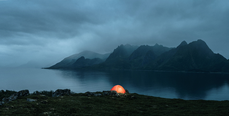 Illuminated tent at the lofoten islands on the rainy evening with copy spaceの写真素材