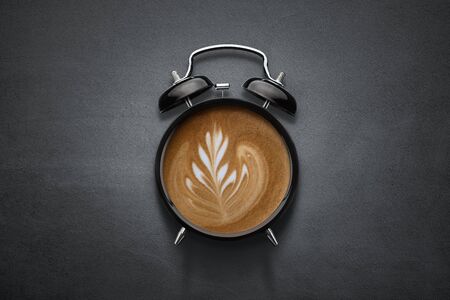 Conceptual coffee clock on dark concrete background with copy spaceの写真素材