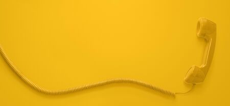 Red vintage telephone handset isolated on yellow background with copy spaceの写真素材