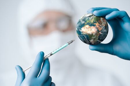 Pandemic concept, close up of scientist injecitng vaccine into the earthの写真素材