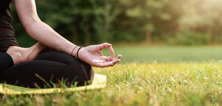 Close up of young woman practicing yoga in the back yard with copy spaceの写真素材