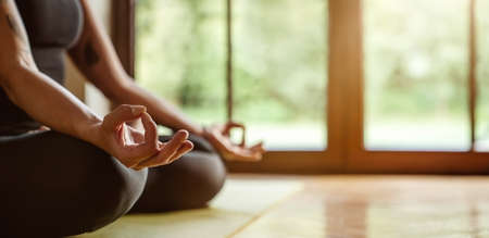 Close up of young woman practicing yoga at home with copy spaceの写真素材