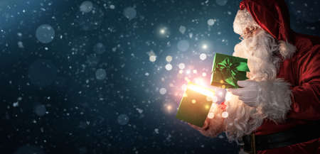 Curious Santa Claus opening magic gift box with copy spaceの写真素材