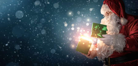 Curious Santa Claus opening magic gift box with copy spaceの写真素材