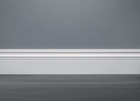 Close up of decorative, molding white baseboard in empty room with copy spaceの写真素材