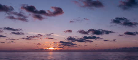 Panoramic view of the calm sunrise over the ocean with copy spaceの写真素材