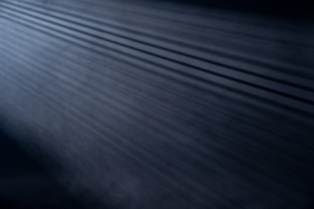Light rays coming through the bleachers isolated on black background with copy space