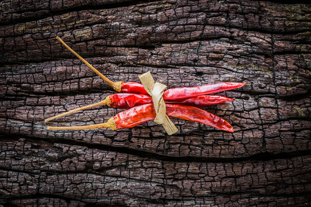 Dry chili peppers are placed on old wood.の写真素材